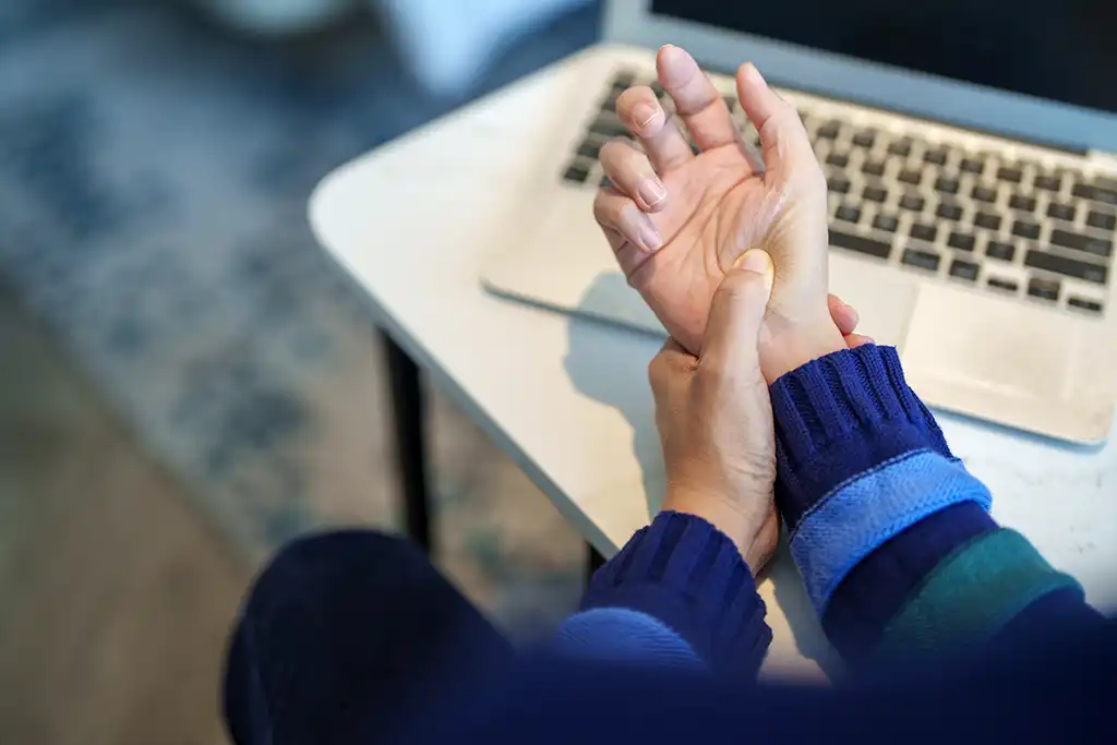 person holding hand and wrist as if in pain
