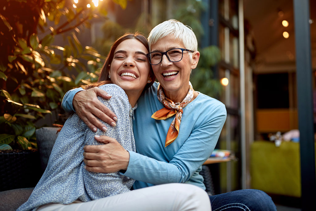 mother and adult daughter smiling together